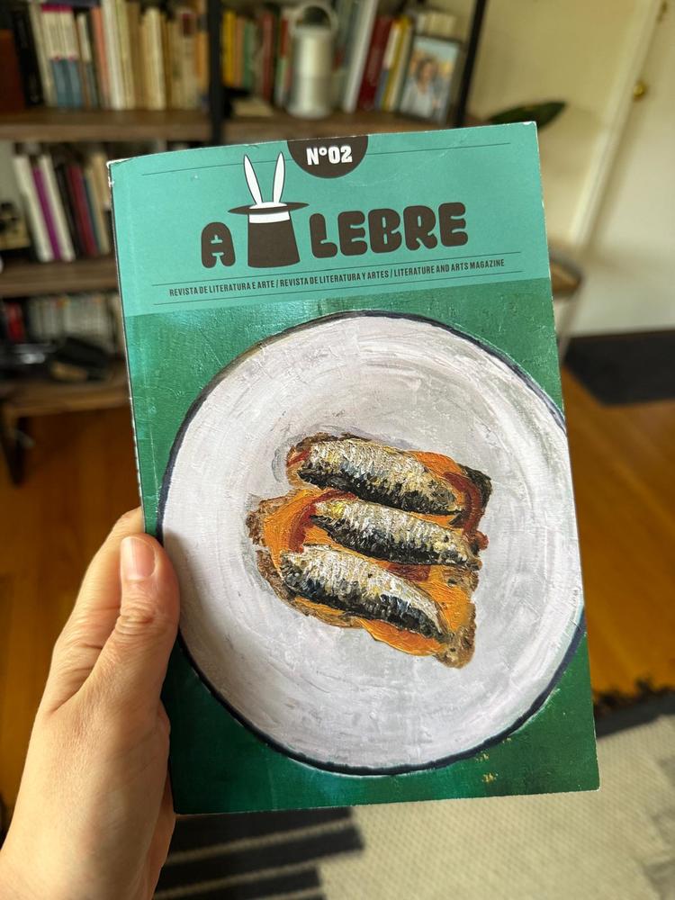 Cover of the magazine with an artistic image of a plate with sardines over turquoise background